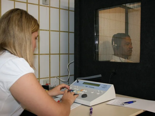 Szakápoló audiométerrel hallásvizsgálatot végez a munkavállalón